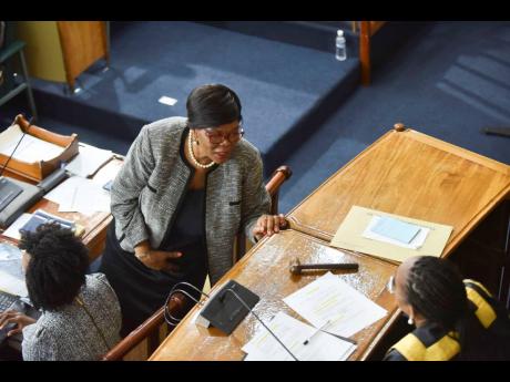 
Former clerk to the Houses of Parliament Valrie Curtis (standing) speaks with House Speaker Juliet Holness during a sitting of the House of Representatives in March. 