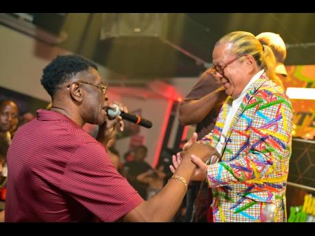 Credit: Contributed Winston 'Wee Pow' Powell (left) shares well wishes with Brian 'Ribbi' Chung.