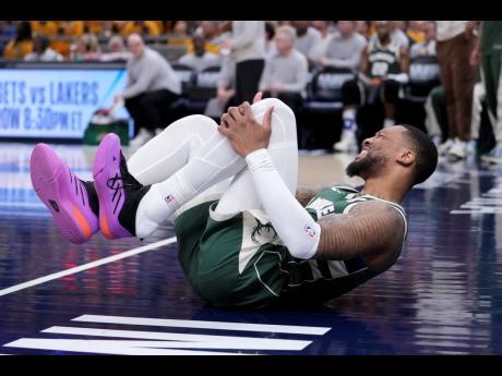 
Milwaukee Bucks guard Damian Lillard grabs his leg after being injured during the first half in Game 2 against the Indiana Pacers in an NBA basketball first-round playoff series, on Friday.