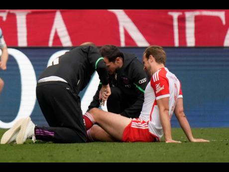 
Bayern Munich’s Harry Kane is assisted during the German Bundesliga football match against Eintracht Frankfurt, at the Allianz Arena in Munich, Germany, yesterday.