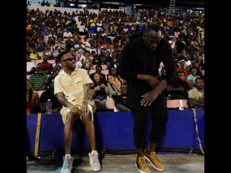 Dancehall veteran, Cham (left) looks on as Usain Bolt shows off his dance moves trackside at Racers Grand Prix held at the National Stadium in St Andrew, on Saturday, June 3, 2023.