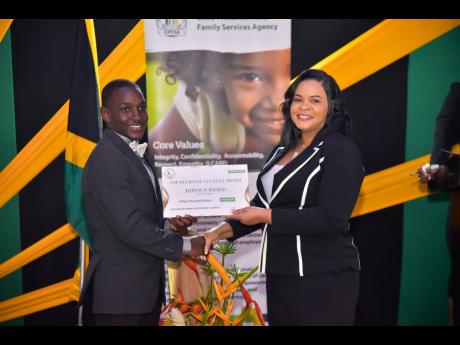 Chief Executive Officer of the Child Protection and Family Services Agency (CPFSA), Laurette Adams-Thomas, presents Jehvoun Byfield with a certificate in the ‘Top Regional Student Award’ category of the 2024 CPFSA Educational Achievement Awards.