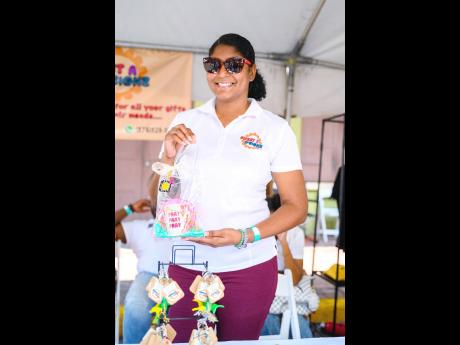 Thaidia Masters, the owner of Sweet A D’signz, smiles as she holds a custom-made mug from her online business.