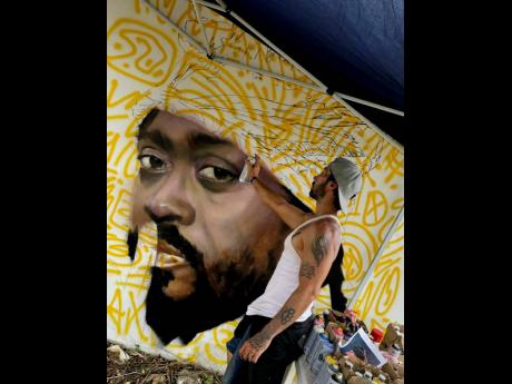 Artist Maximiliano Bagnasco works on a portrait of Beenie Man. 