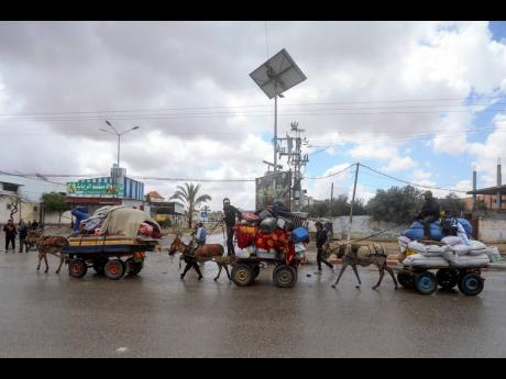 Palestinians flee from the eastern side of the southern Gaza city of Rafah after the Israeli army orders them to evacuate ahead of a military operation, in Rafah, Gaza Strip, yesterday. The order affects tens of thousands of people and could signal a broad