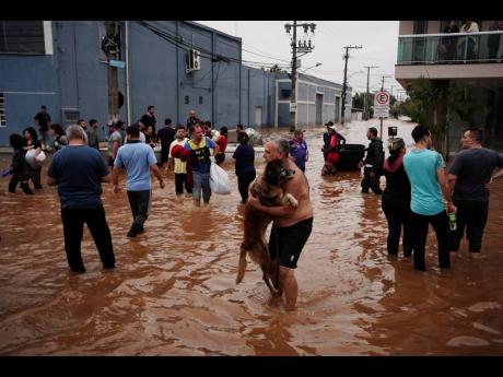 Residents evacuate from a neighborhood flooded by heavy rains, in Canoas, Rio Grande do Sul state, Brazil, Saturday, May 4.