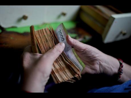 AP 
A worker counts money at a grocery store in Buenos Aires, Argentina, November 21, 2023.