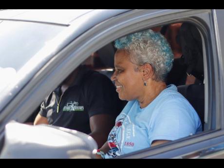 Credit: Contributed Photos Principal Margaret Campbell checks out the features of the sports car provided by Street Xtream on STGC Day during parade on campus.