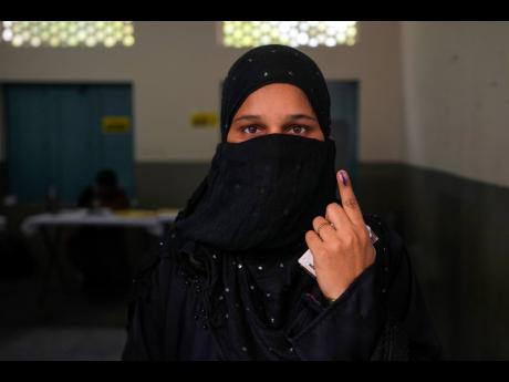 A woman shows the indelible ink mark on her index finger after casting her vote in a polling station during the fourth phase of general election in Hyderabad, India, yesterday.