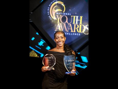 Tashae Bowes displaying her Prime Minister National Youth Award for Excellence in academics (left) and the ‘Viewers’ Choice’ Award (right).