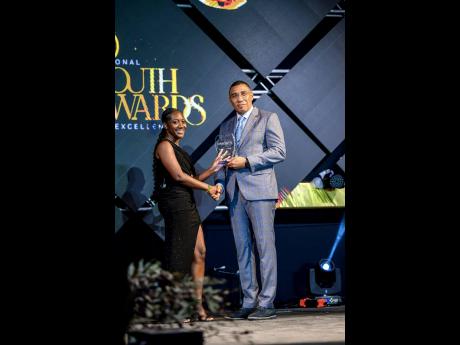 Tashae Bowes accepting the Prime Minister National Youth Award for Excellence in academics from Prime Minister Andrew Holness.