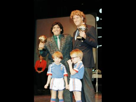 In this file picture, Argentine football star Diego Maradona (left) and West German goalkeeper Harald Schumacher hold their World Cup Golden Balls for best player and goalkeeper, respectively, at the 1986 World Cup in Mexico.