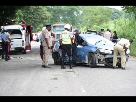 Credit: File
Police personnel examine two of the vehicles involved in a smash-up along Church Road in St Catherine on Monday. Religious leader Kevin O. Smith and Constable Orlando Irons died from crash-related injuries.
