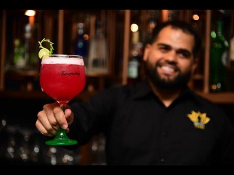 David Quilen, restaurant Manager at Orchid Thai presents a glass of the The Nanda Bird.