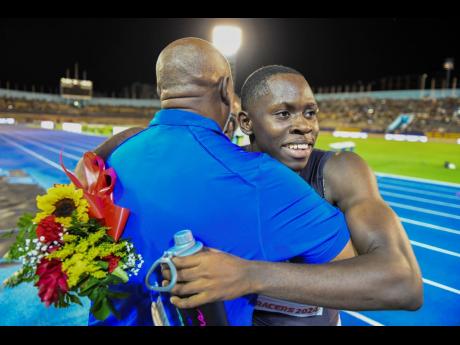 Credit: Gladstone Taylor/Multimedai Photo Editor Racers Track Club coach Glen Mills (left) hugs his charge Oblique Seville after the latter stormed to a world lead, 9.82 seconds in the men’s 100 metres at the Racers Grand Prix at the National Stadium on Saturday.