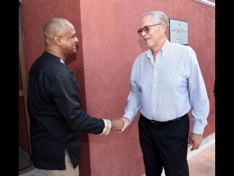 Former Prime Minister Bruce Golding (right) is greeted by Dr Christopher Malcolm, deputy dean of the Faculty of Law at The UWI Mona, on his arrival for ‘A Reasoning with PJ Patterson’ on Wednesday.
