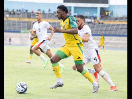 Reggae Boy Renaldo Cephas runs past a defender on his way to setting up an assist for Shamar Nicholson during their Concacaf World Cup qualification game at the Dominican Republic inside the National Stadium yesterday. 