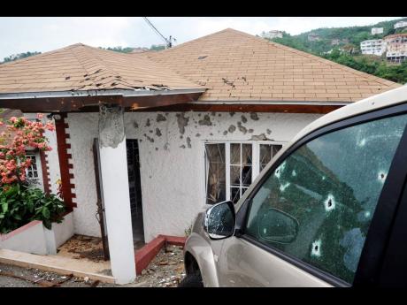The bullet-riddled house and vehicle at the Kirkland Heights home of Keith Clarke.