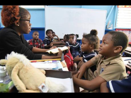 Elisa Nelson (left), grade 1 teacher at Grove Primary School, engages her students in a reading session. 