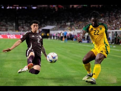 Mexico’s Jorge Sanchez (left) tries to block a cross from Jamaica’s Greg Leigh during a Copa America Group B match at the NRG Stadium in Houston on Saturday.