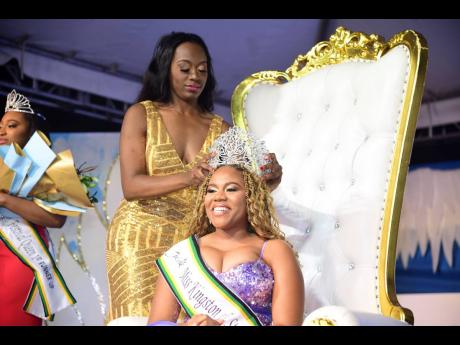 A grateful Daindra Harrison is crowned by outgoing Miss Kingston and St Andrew Festival Queen, Jhanielle Powell (left).