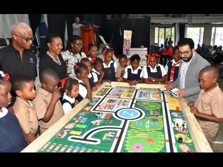 Credit: Contributed State Minister in the Ministry of Education and Youth, Marsha Smith (fifth left), looks on while robotics instructor, Zebra Robotics in Canada, Tahmoor Naeem (second right), conducts a robotics lesson with students from Bryce Primary School in Manchester.