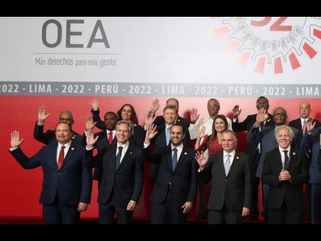 US Secretary of State Antony Blinken (second from the left) waves as he stands with the leaders and representatives of the countries of the Organization of American States during a group photo at the 52nd OAS General Assembly in Lima, Peru, Thursday, Octob