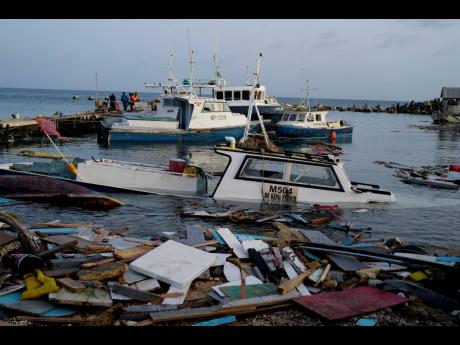 Credit: Ricardo Mazalan Boats damaged by Hurricane Beryl wade in the water at the Bridgetown Fisheries, Barbados on July 2.