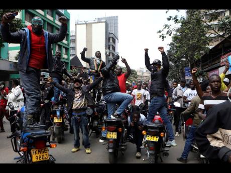 Demonstrators on motorcycles gesture during a protest in Nairobi, Kenya, yesterday.