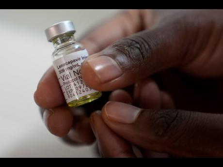 A pharmacist holds a vial of lenacapavir, at the Desmond Tutu Health Foundation's Masiphumelele Research Site, in Cape Town, South Africa, Tuesday, July 23, 2024. (AP Photo/Nardus Engelbrecht)