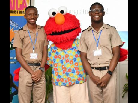 Beaches’ Sesame Street character Elmo congratulates the winner, Tal Melbourne (left), and runner-up Hassan Smith after the competition.