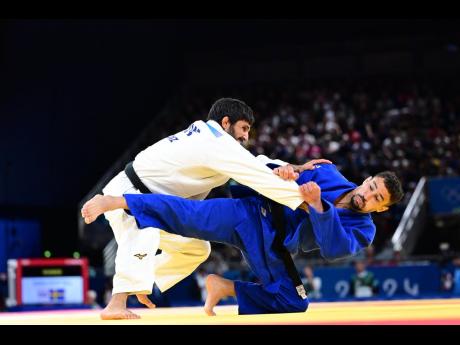 Jamaica’s Ashley McKenzie attempts a leg lock against Salih Yildiz of Turkey in the men’s -60kg elimination round of 16 judo match at Champs de Mars Arena in  Paris, France, yesterday.