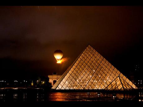 The Olympic Flame rises on a balloon over the Louvre after being lit in Paris, France, during the opening ceremony of the 2024 Summer Olympics, on Friday.