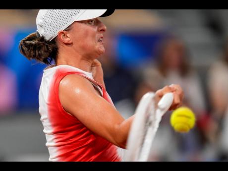 Iga Swiatek of Poland returns the ball against Irina-Camelia Begu of Romania during the women’s singles tennis competition, at the 2024 Summer Olympics in Paris, France, yesterday.