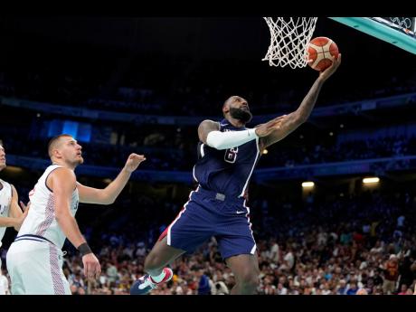 LeBron James (right) of the United States, shoots as Nikola Jokic of Serbia defends during a men’s basketball game at the 2024 Summer Olympics yesterday in France. 