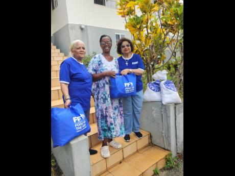 Caribbean Community of Retired Persons (CCRP) St Elizabeth parish representative, Joan Martin (centre), receives a donation of care packages for distribution to the Malvern and Treasure Beach communities from CCRP founder and CEO, Jean Lowrie-Chin (right),