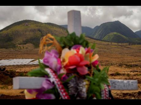 A cross adorned with leis is seen at a memorial for wildfire victims on Saturday, July 6, in Lahaina, Hawaii.