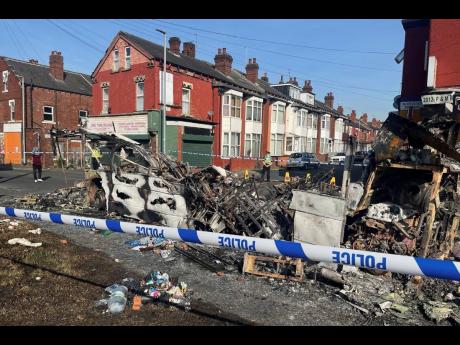A burnt-out car in the Leeds suburb of Harehills on Friday, July 19, following an outbreak of disorder on Thursday evening. 