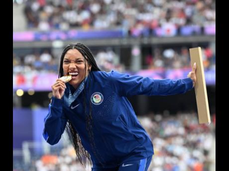 Quirky fan favourite, Tara Davis-Woodhall of the United States checks to see if her long jump gold medal is real.