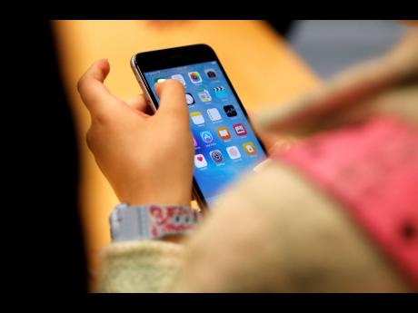 A child holds an iPhone at an Apple store in 2015 in Chicago. Parents - and even some teens themselves - are growing increasingly concerned about the effects of social media use on young people.