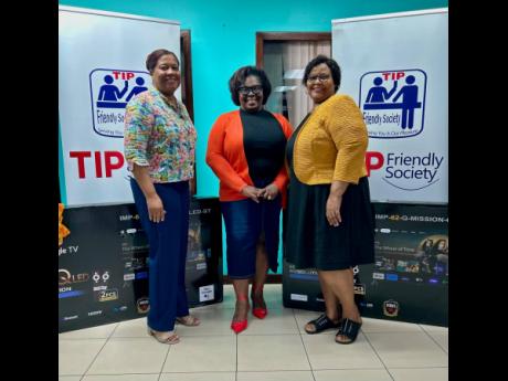 Judy Miller-Smith (left), marketing manager, and Judith Wilson (right), branch operations manager of TIP Friendly Society, proudly donate two 55-inch flat screen TVs to Principal Jacqueline Hendricks-White (centre) of Lyssons Centre of Excellence. The scho