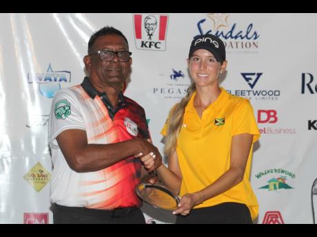Jamaica’s Mattea Issa receives the runner-up Peter Hale trophy from Kallan Sooknoor of the Trinidad and Tobago for the Girls’ 18 and Under category at the 36th Caribbean Amateur Junior Golf Championship which was held at the Caymanas Golf Course.