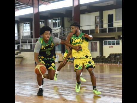 Credit: Ashley Anguin Yannick Noumbissi (left) of P.H.A.S.E.1 Academy (PIA) International works his way around defender Joshua Ferguson of P.H.A.S.E.1 Academy (PIA) Trelawny during the JamRockers Basketball Under-17 Classics at Montego Bay Community College yesterday 2024. P1