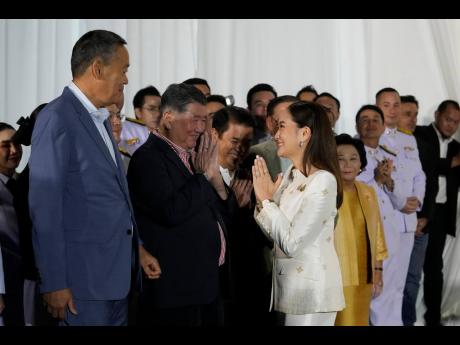 Thailand’s new Prime Minister Paetongtarn Shinawatra (right) pays respect to former Thai Prime Minister Srettha Thavisin (second left) after receiving the royal endorsement for the post at the Pheu Thai party headquarters in Bangkok.