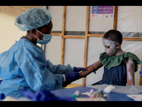 A health worker attends to Lucie Habimana, 13, an mpox patient, at a treatment centre in Munigi, eastern Congo on August 16.