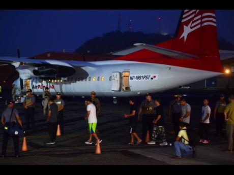 Colombian migrants walk in handcuffs and shackles to a plane for deportation at Marcos A. Gelabert de Albrook Airport in Panama City on Tuesday. AP 