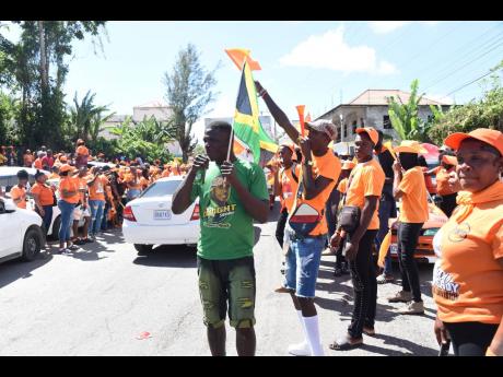 In this February photo, a Jamaica Labour Party supporter is surrounded by People’s National Party supporters in Kellits on nomination day for parish council elections. 
