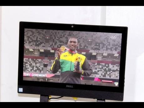 Credit: Paul Williams Hansle Parchment in the video loop displaying the gold medal he earned during the 2020 (2021) Olympics in Tokyo, Japan.