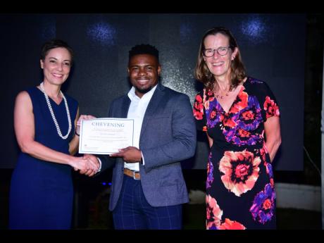 Credit: Antoine Lodge Senator Kamina Johnson Smith (left), minister of foreign affairs and foreign trade, and Judith Slater, British high commissioner to Jamaica, present Anthony McKenzie with his certificate of acceptance at the 2024 Chevening Scholarship Award Ceremony and Re