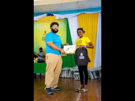A student receives her branded SVF knapsack, $5,000 voucher, and certificate of participation, from Nile Sadler, senior lead instructor at Halls of Learning at the close of the Supreme Ventures Foundation Junior Creators Summer Robotics Camp.